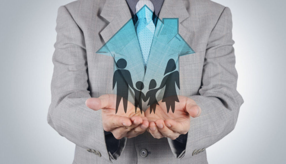 businessman hand holding 3d house with family icon as insurance